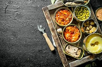 Various open tin cans of canned food on tray.