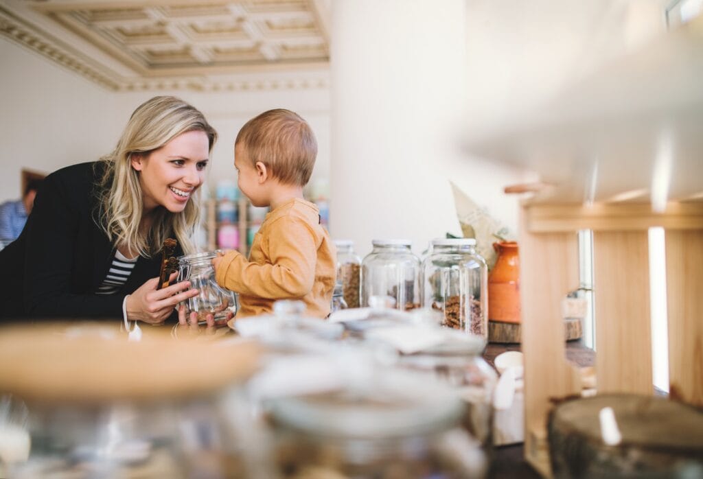 Zero-Waste-Kochen – Nachhaltig & clever: So reduzierst du Küchenabfälle auf ein Minimum 4 - Küchenhelferlein A young woman with a toddler boy buying groceries in zero waste shop.